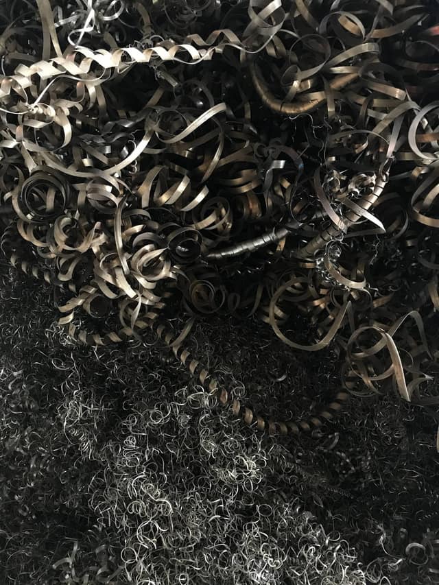 Coiled steel turnings and fine swarf piled together.