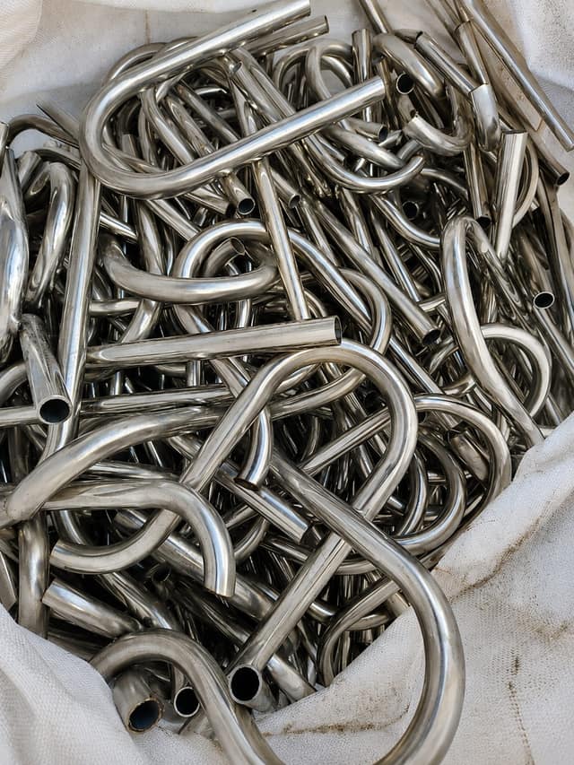 Coiled stainless steel tube scrap gathered in a bulk bag.