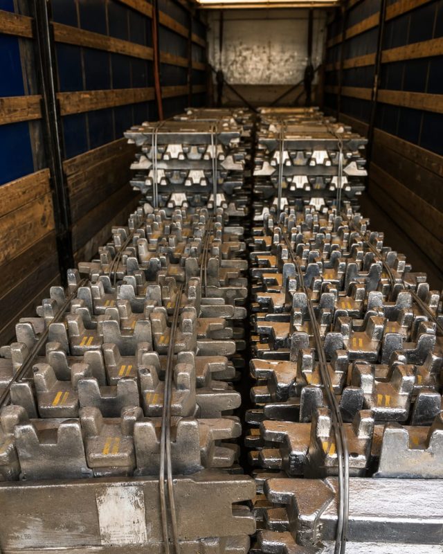 Aluminium alloy ingots stacked in rows inside a truck trailer.
