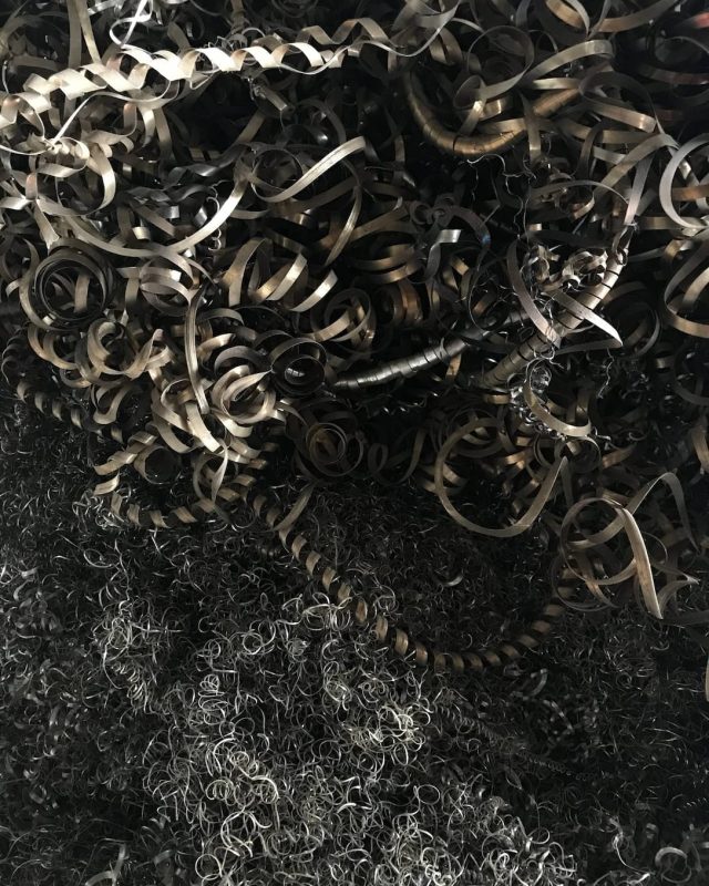 Coiled steel turnings and fine swarf piled together.