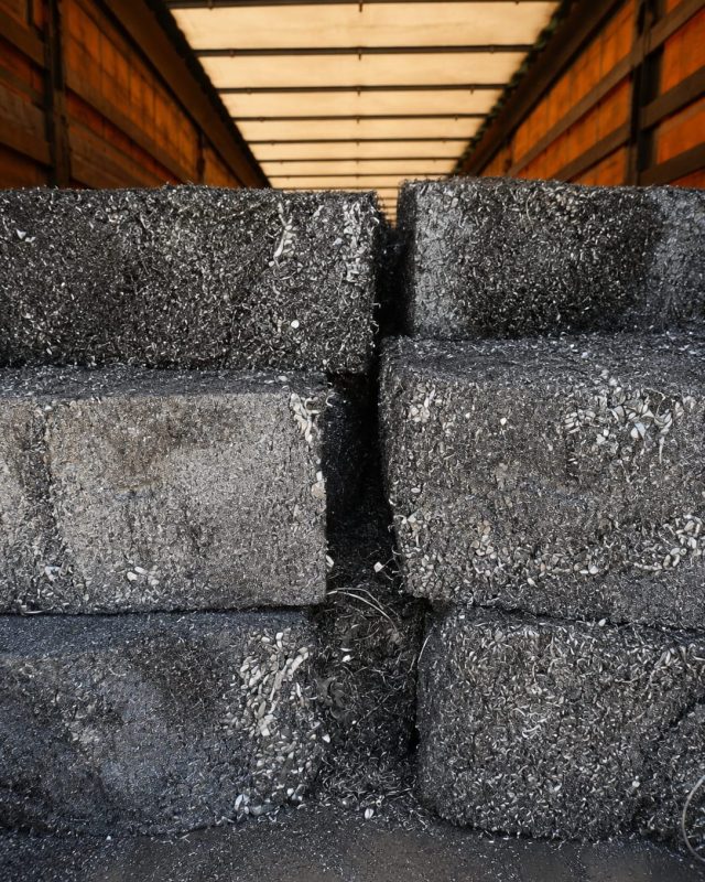 Baled aluminium turnings stacked inside a trailer.